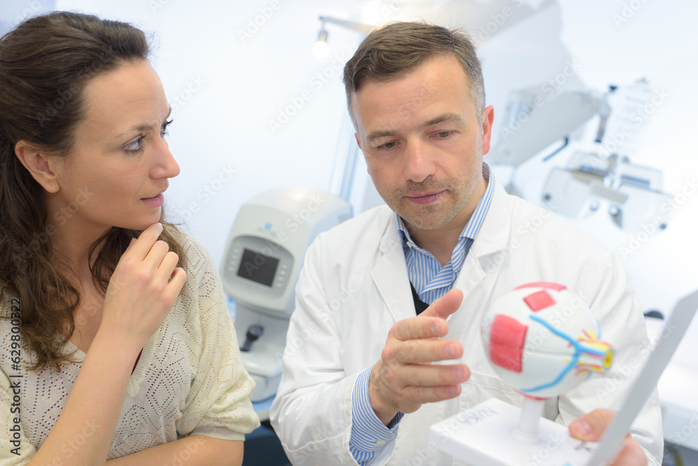 Fototapeta premium doctor showing eye model to patient