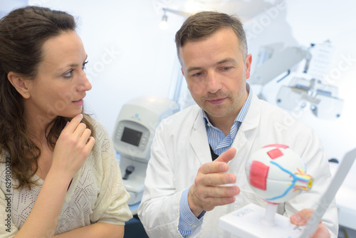 doctor showing eye model to patient