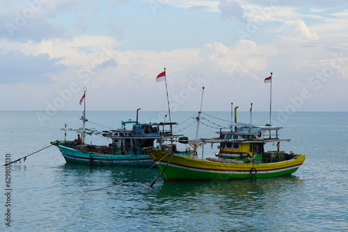 outdoor shoot showing indonesian flag on red and white, the middle of the sea fisherman boat to welcome the commemoration of Indonesia's independence day 17 August.
