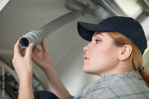 woman mending the leak under the sink photo