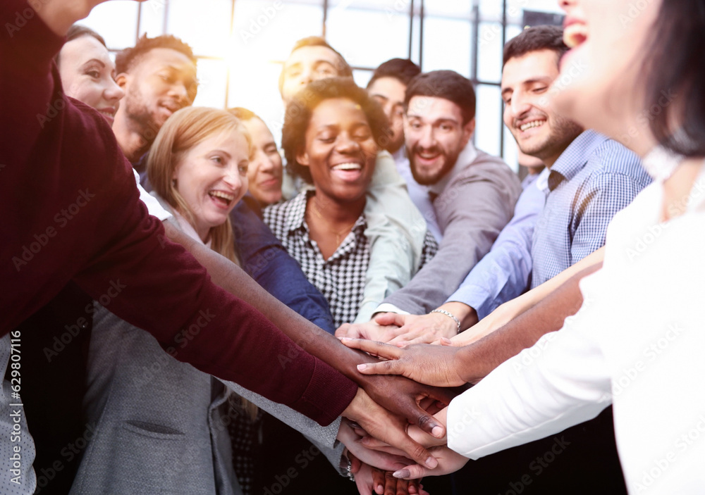 © Katsiaryna - Large business team showing unity with their hands together