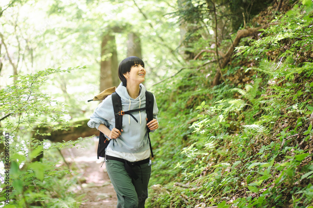新緑の山道を歩いている若い日本人女性 新緑の山道を歩いている若い日本人女性