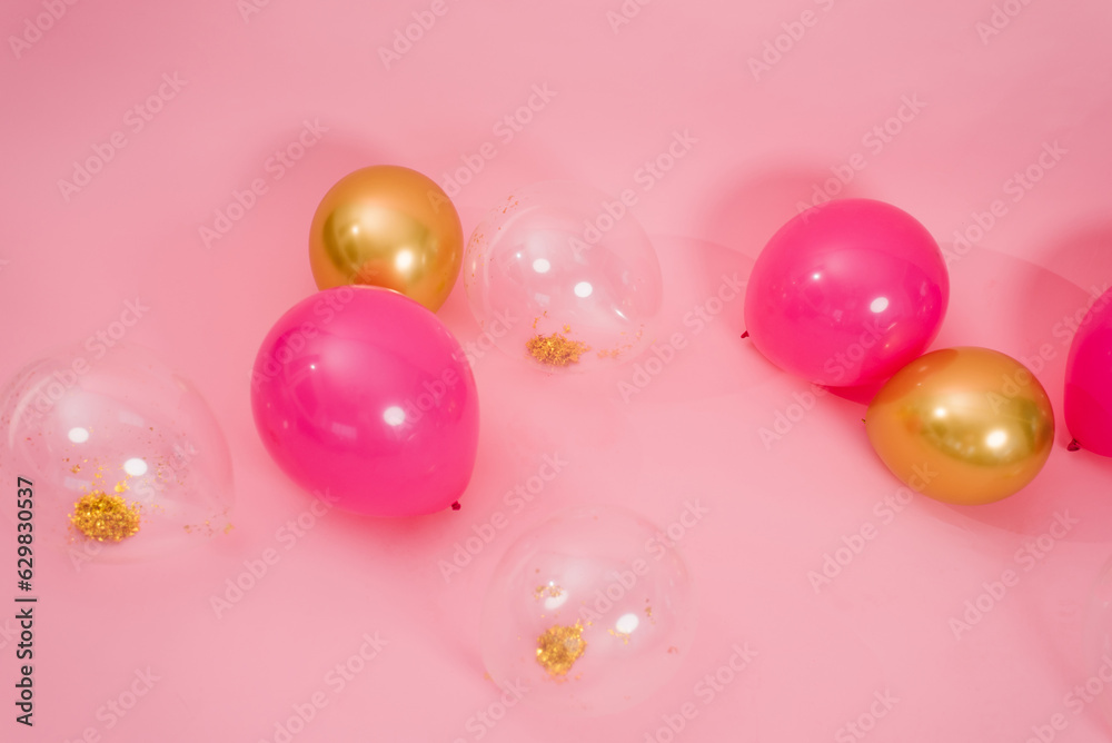 Beautiful multicolored pink, gold and transparent with confetti or sequins lie on a pink background in a chaotic order. Concept of Valentine's day, birthday, mother's day in barbiecore style