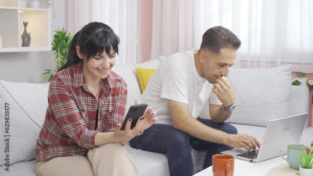 Married couple hanging out on laptop and phone. Technology use at home. Married couple hanging out on laptop and phone. Technology use at home.