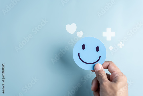 Fototapeta Naklejka Na Ścianę i Meble -  Hands hold Happy smile face. mental health positive thinking and growth mindset, mental health care recovery to happiness emotion.