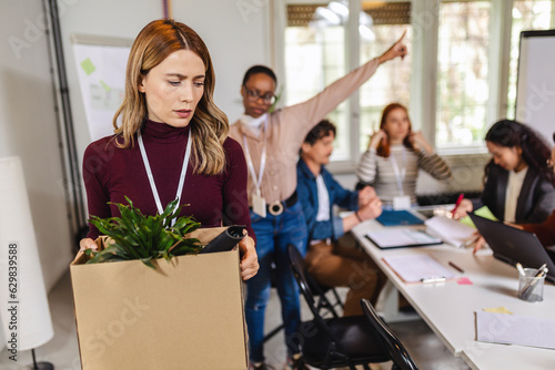 Foto Business woman carrying packing up all her personal belongings and files into a brown cardboard box to resign in the modern office, resign concept