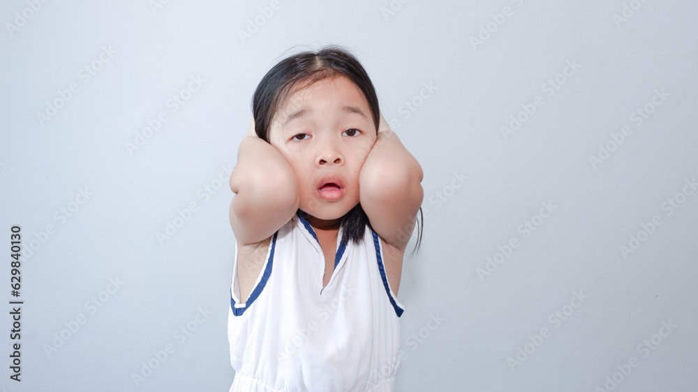 portrait of little asian girl tired, lethargic, headache, bad mood concept. studio shot with light color background. portrait of little asian girl tired, lethargic, headache, bad mood concept. studio shot with light color background.