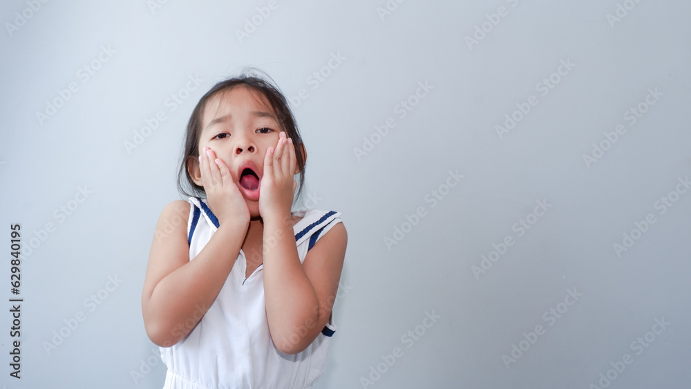 portrait of little asian girl tired, lethargic, headache, bad mood concept. studio shot with light color background. portrait of little asian girl tired, lethargic, headache, bad mood concept. studio shot with light color background.