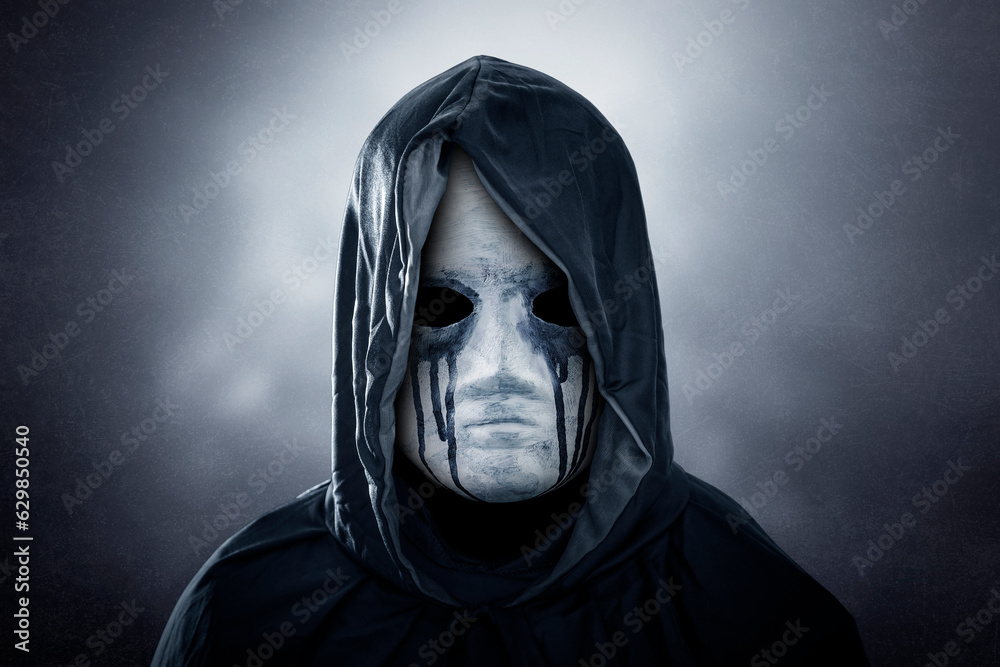 Spooky figure with hooded cape over dark misty background
Spooky figure with hooded cape over dark misty background