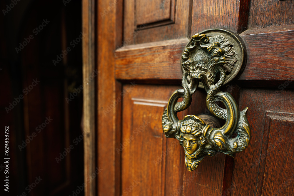 Door knocker in the form of a face on a wooden door in Bran Dracula castle entrance. Transylvania,Romania,Europe. Door knocker in the form of a face on a wooden door in Bran Dracula castle entrance. Transylvania,Romania,Europe.