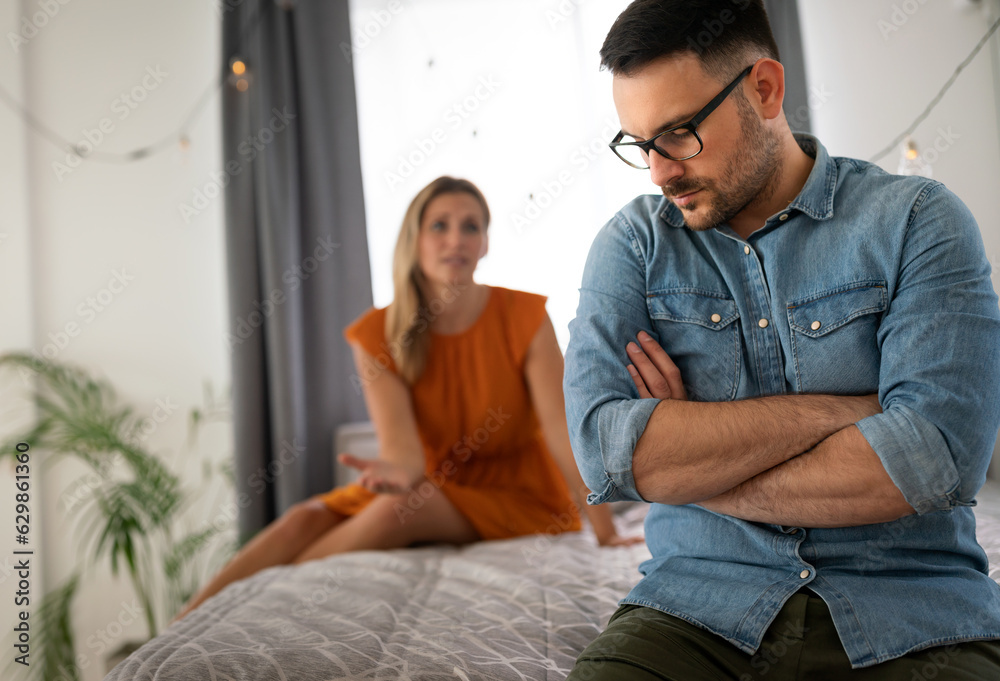 Sad pensive couple thinking of relationships problems sitting on sofa, conflicts in marriage. Sad pensive couple thinking of relationships problems sitting on sofa, conflicts in marriage.