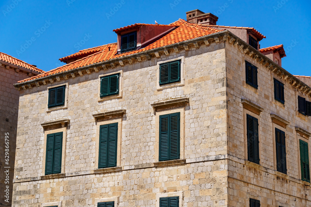 street view of the old town of Dubrovnik in Croatia, medieval European architecture, city streets, windows with wooden shutters, red tiled roofs, the concept of traveling in the Balkans