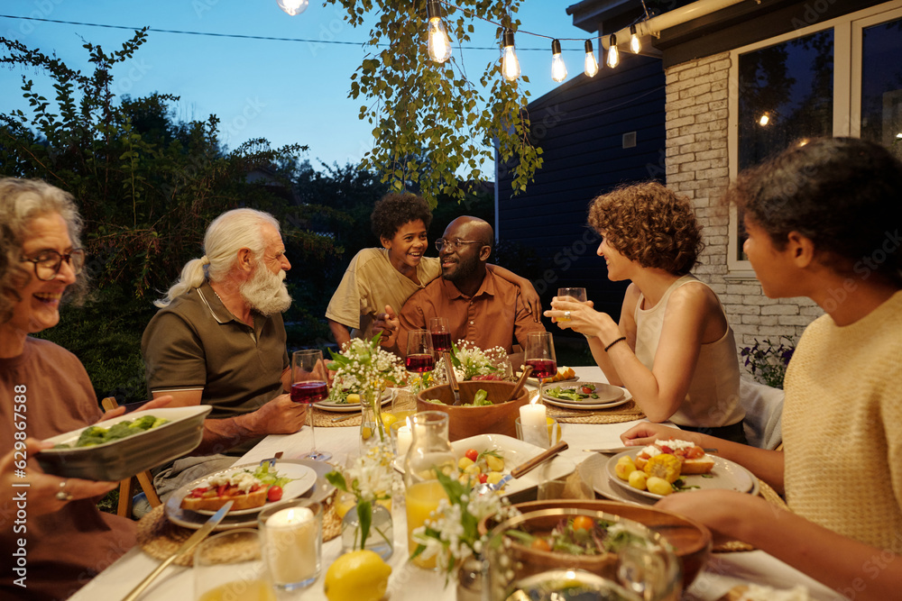 © pressmaster - Cute boy and his father sitting by served table among other members of family while enjoying communication and tasty homemade food © pressmaster - Cute boy and his father sitting by served table among other members of family while enjoying communication and tasty homemade food