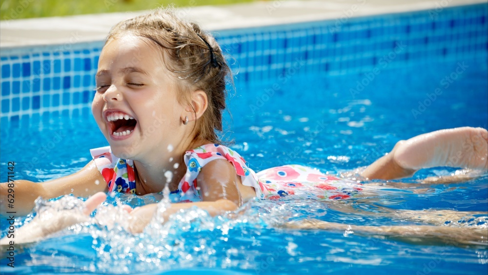 Little girl in sunglasses learning to swim in a pool with her mother