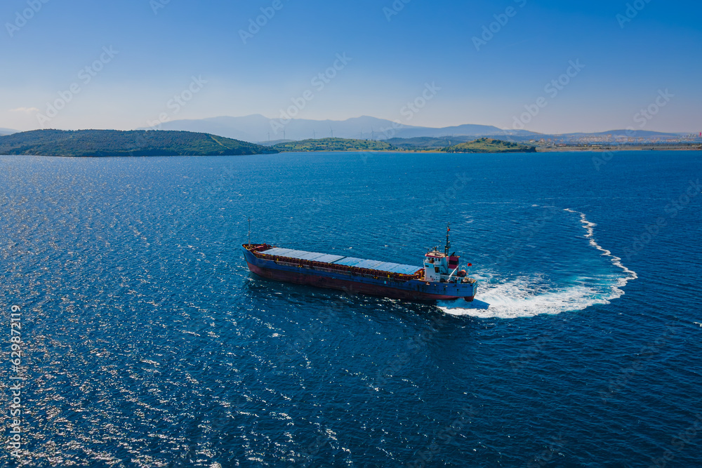 Fototapeta premium Aerial shot of Bulk carrier ship manoeuvring in anchorage in sea