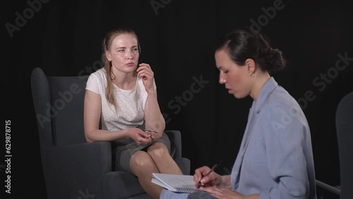 woman at the reception at the expert. Two Caucasians sit in armchairs and communicate. slow motion video. High quality Full HD video recording photo