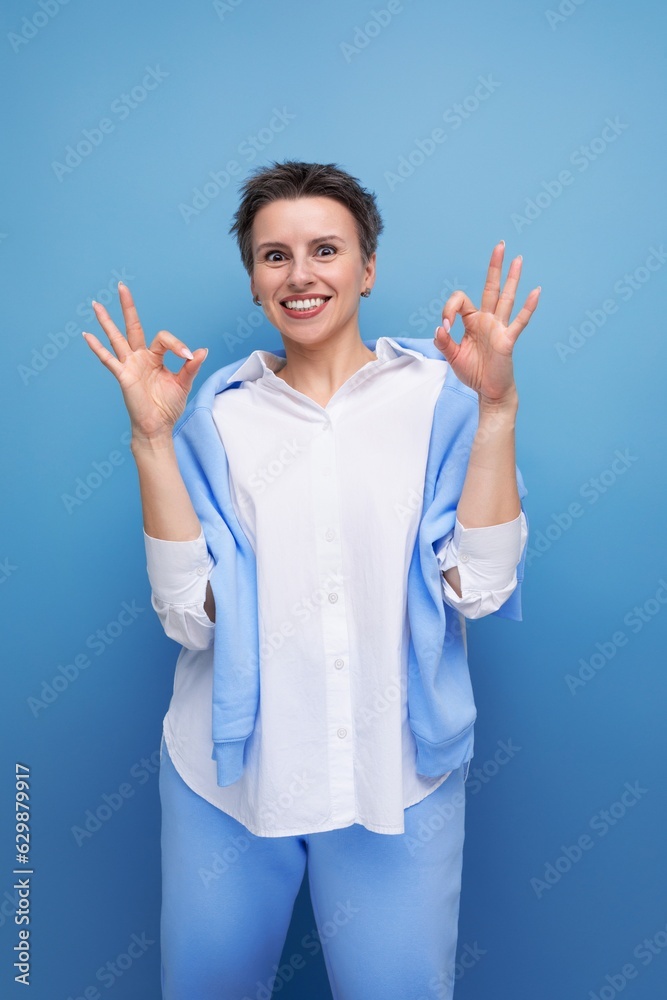 confident fashionable young lady with tousled hair in a white shirt in an informal setting confident fashionable young lady with tousled hair in a white shirt in an informal setting