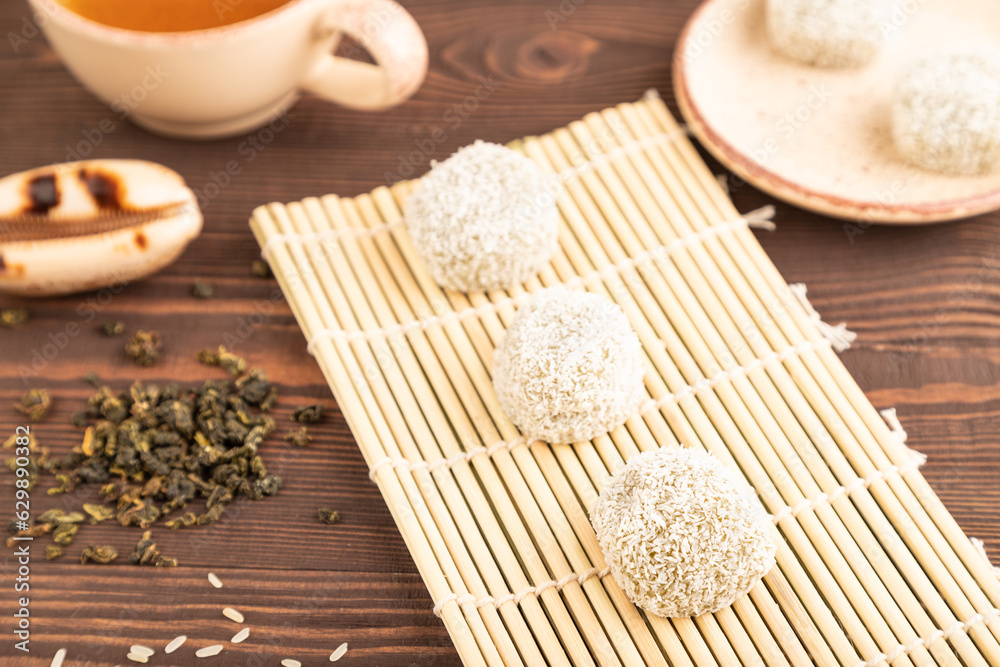 Japanese rice sweet buns mochi filled with pandan and coconut jam on brown wooden, side view, selective focus Japanese rice sweet buns mochi filled with pandan and coconut jam on brown wooden, side view, selective focus