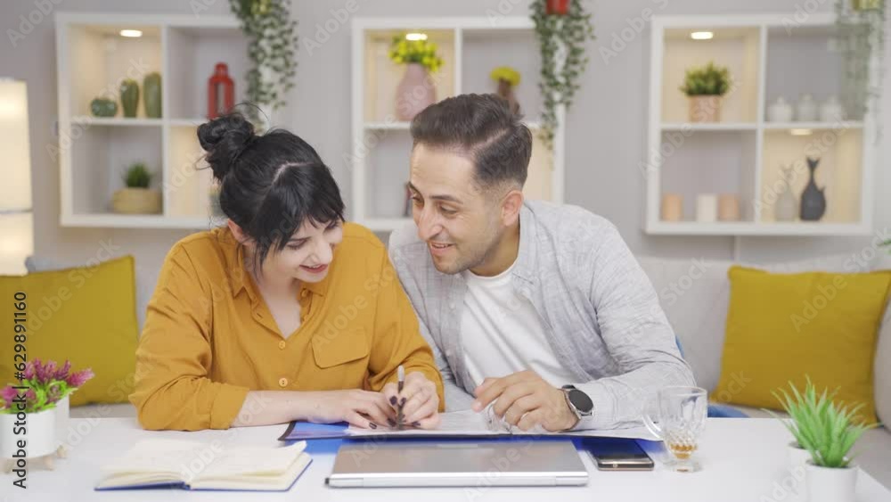 The couple looking at the file nods and is happy. The couple looking at the file nods and is happy.
