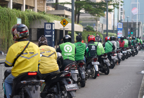 Cuadro en lienzo Motor cycle taxi drivers parking on the side of the Sudirman Road waiting for pa