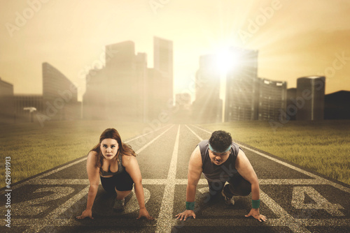 overweight people ready to compete and try to chase their dream with numbers 2024 on the running track © Creativa Images