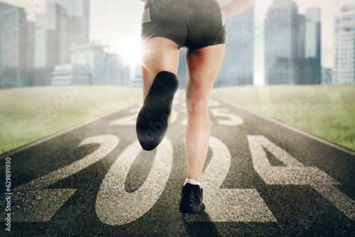 Close up of young woman foot running and exercising on the track with 2024 new year numbers