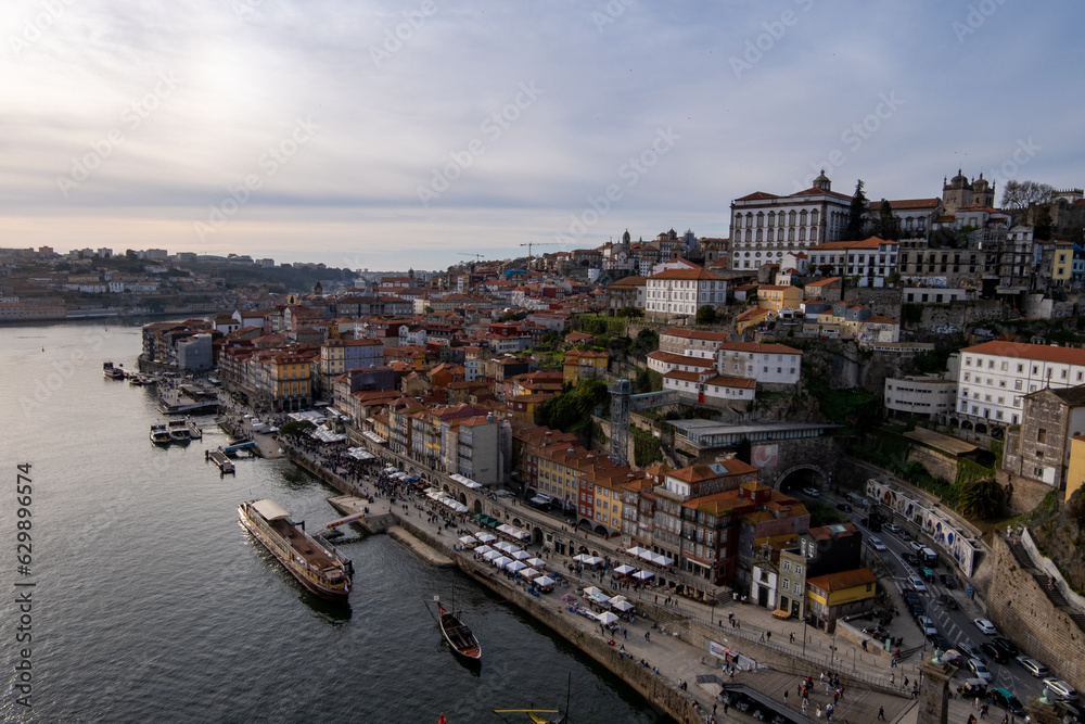 Panorámica de la ciudad portuguesa de Oporto con sus edificios y monumentos a un lado y el río Duero al otro al atardecer.