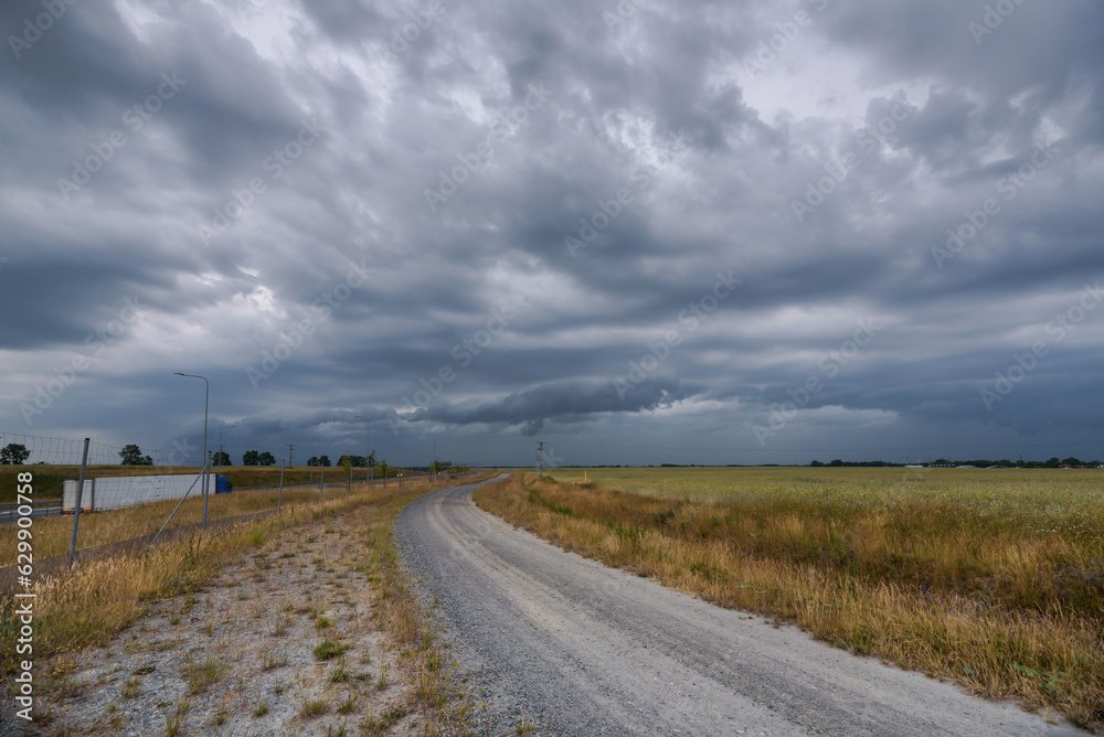 RAIN CLOUDS - Cloudy weather on dirt road and farmland
