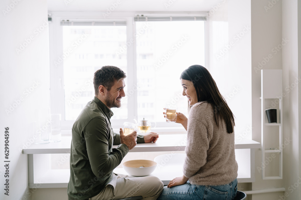 Happy couple having tea in glasses at table Happy couple having tea in glasses at table