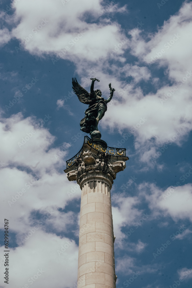 Fotografía en vertical del Monument aux Girondins en Burdeos, Francia, con el cielo con nubes detrás.