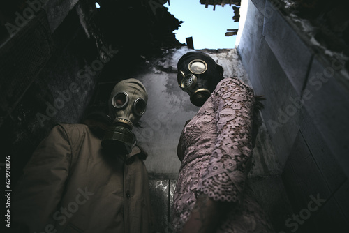 A Man and Woman in gas masks inside a ruined building with a leaky roof in the dark, apocalypse
