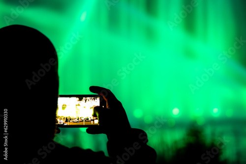 Man recording the light show event in the Planten un Blomen park in Hamburg