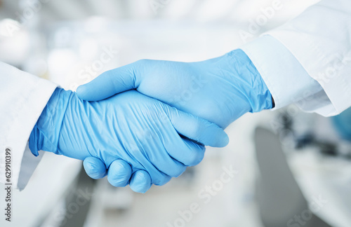 Team handshake, gloves and lab scientist partnership, agreement or collaboration on medical healthcare project. Laboratory, shaking hands and closeup people teamwork, cooperation and welcome partner