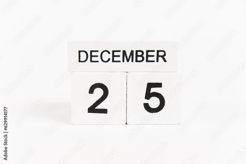 Wooden calendar with the date December 25 on a white background. The concept of preparing for the Christmas and New Year holidays. Wooden calendar with the date December 25 on a white background. The concept of preparing for the Christmas and New Year holidays.