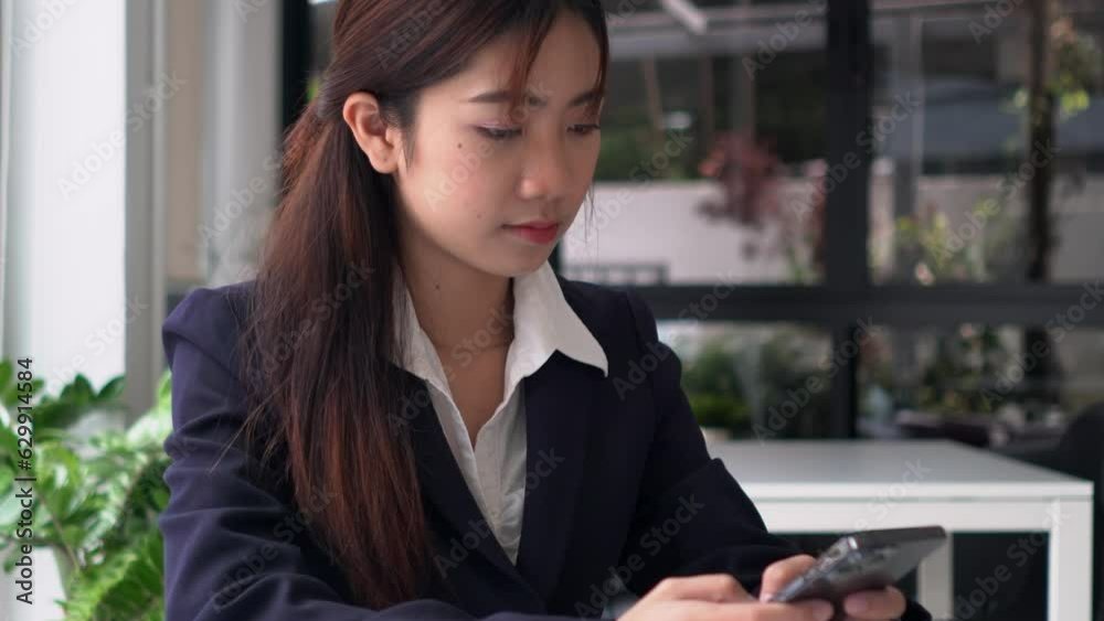 Young Asian business woman in casual using a smartphone to applications on cell phone, reading news. Young Asian business woman in casual using a smartphone to applications on cell phone, reading news.