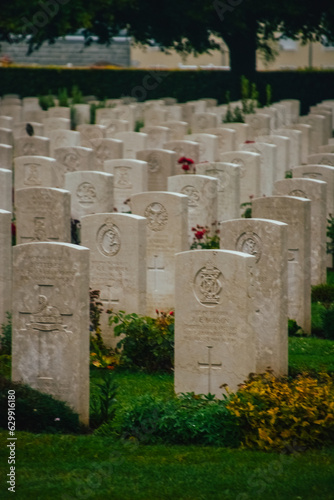 фотографія Fotografía vertical de las tumbas con flores del cementerio americano de Bayeux, Francia, en un día nublado