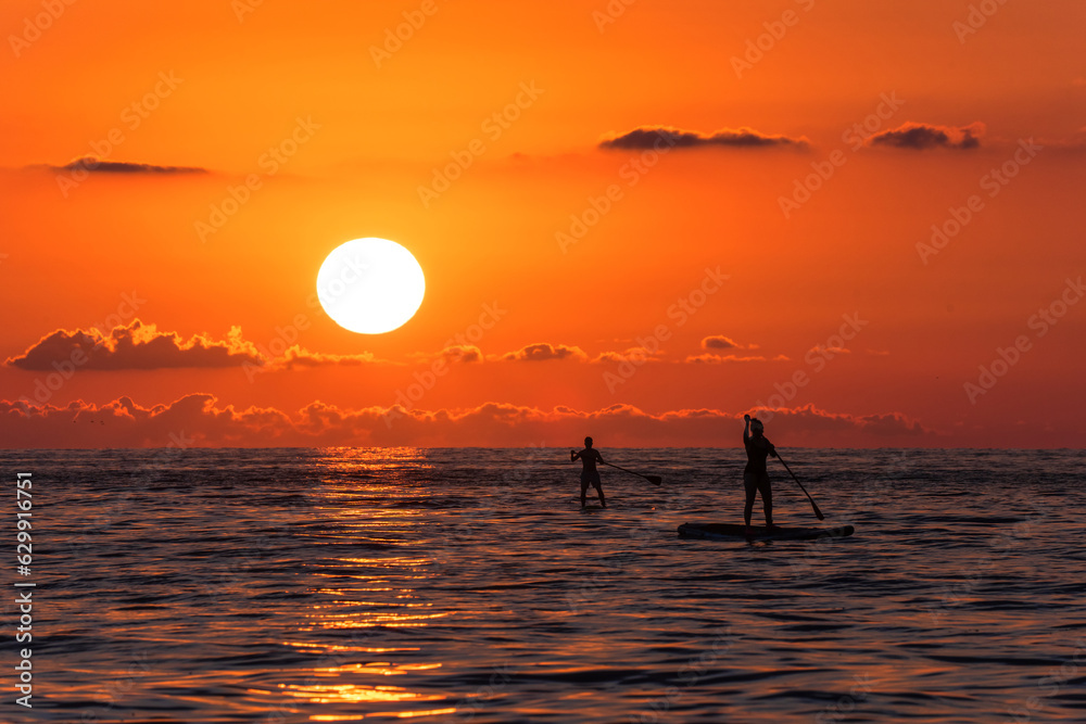People surfing with a paddle in the sea