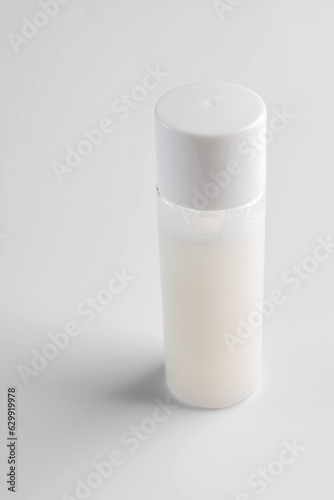 Transparent cosmetic bottle on white background. Healthy modern skin care beauty products. Mockup package of toner or lotion for healty skin. Cleanser or micellar water
