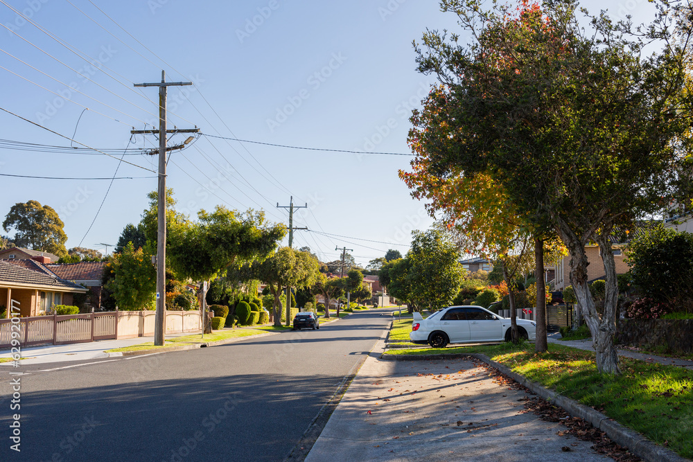 Quiet city suburb street in autumn with car park space beside road Quiet city suburb street in autumn with car park space beside road