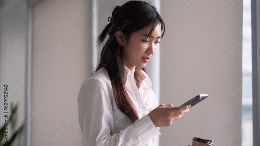 Young Asian business woman in casual using a smartphone to applications on cell phone, reading news. Young Asian business woman in casual using a smartphone to applications on cell phone, reading news.