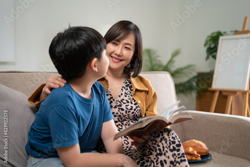 Happy family mom and son reading a book on holiday