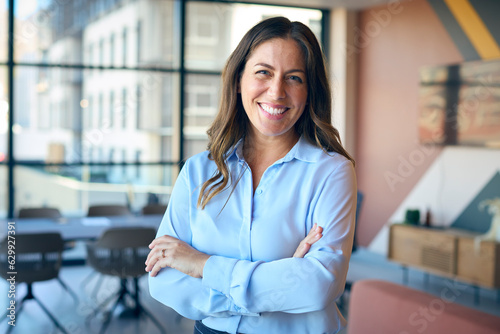 Bild auf Leinwand Portrait Of Smiling Mature Businesswoman Standing In Empty Office