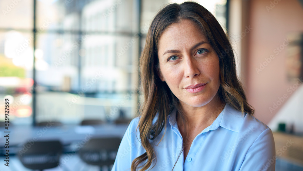 Fototapeta premium Portrait Of Mature Businesswoman With Serious Expression Standing In Empty Office 
