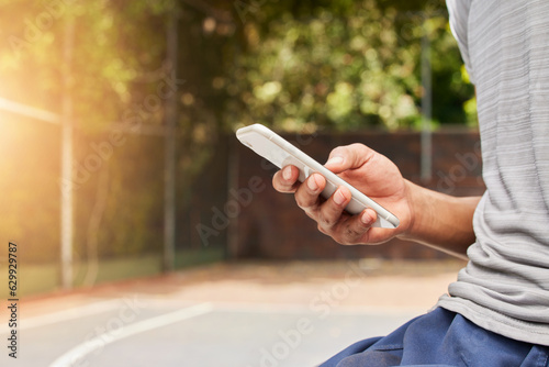 Smartphone in hand, person outdoor and typing, social media scroll and communication with mobile app. Using phone while at sports playground, texting and online chat with contact and technology © Ilzer/peopleimages.com