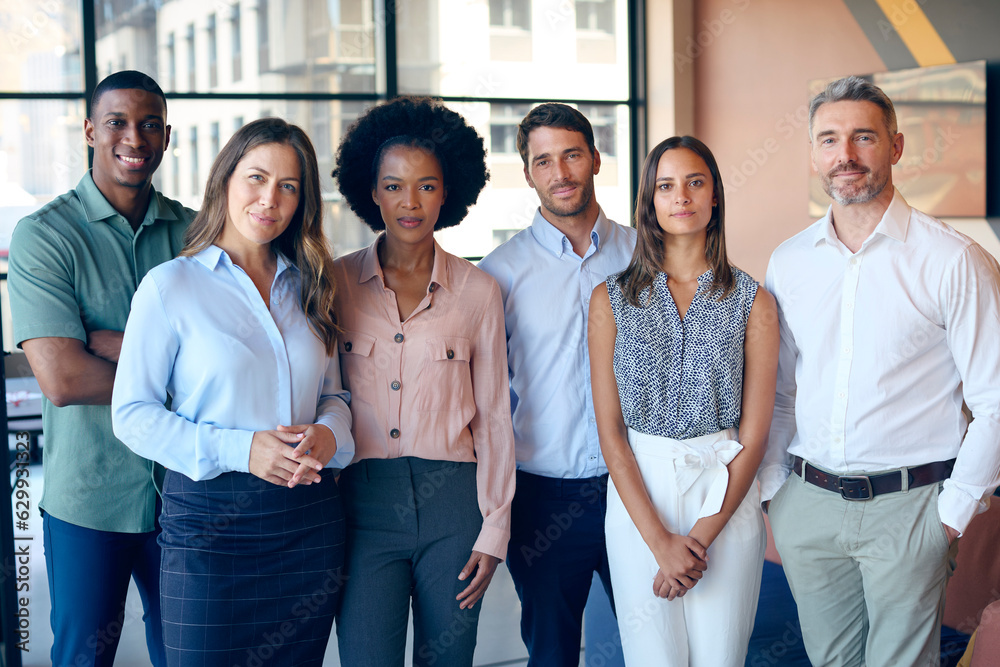 Obraz premium Portrait Of Smiling Multi-Cultural Business Team Standing In Modern Office