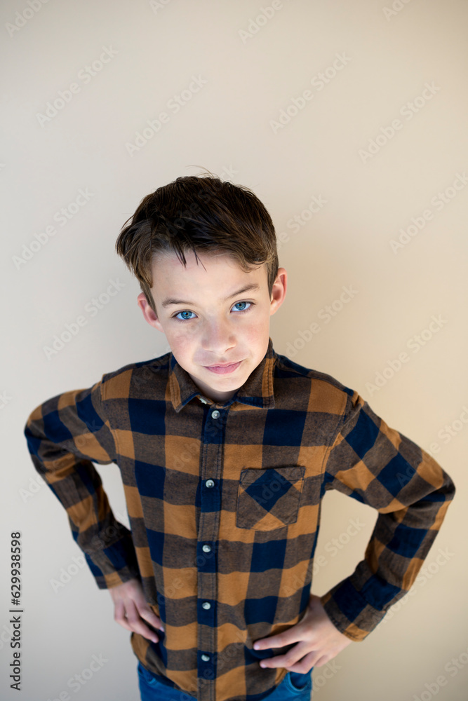 cool pretty young boy with checkered shirt against brown background cool pretty young boy with checkered shirt against brown background