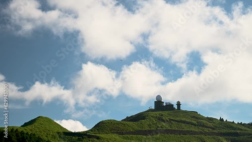 Nature's Canvas: Dynamic White Clouds Drifting Across the Mountain's Blue Sky. The Wufenshan Weather Radar Station stands on the top of the mountain. Taiwan photo