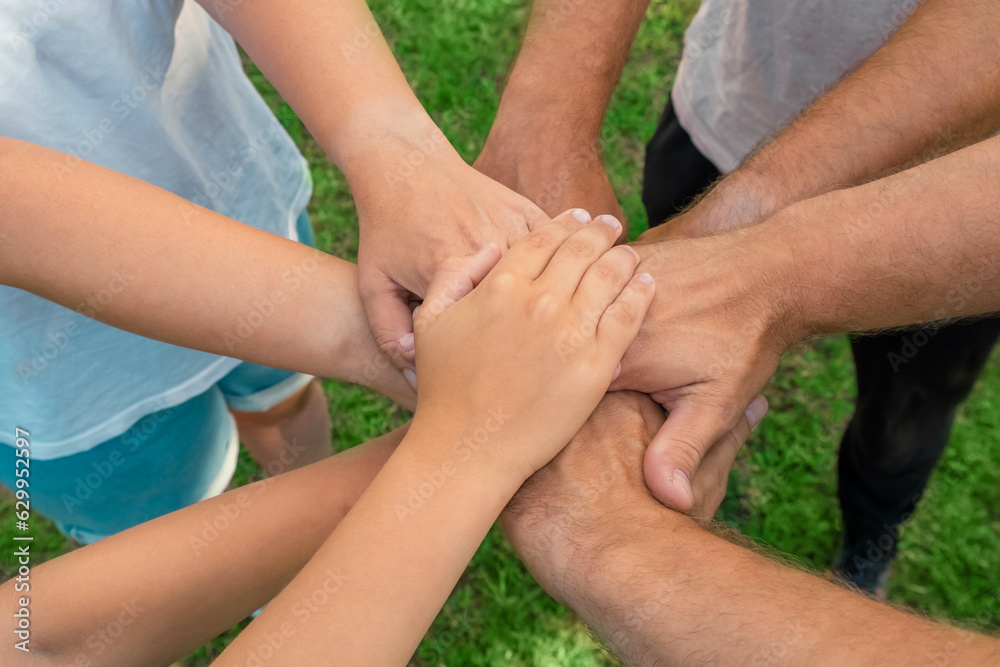 Joined hands as a team. Business teamwork. Close up group of multiracial friends meeting join hands together. Diversity people. Partnership volunteer community. Diverse multiethnic Partners. Top View Joined hands as a team. Business teamwork. Close up group of multiracial friends meeting join hands together. Diversity people. Partnership volunteer community. Diverse multiethnic Partners. Top View