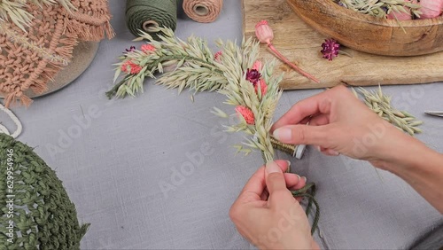 Frau bindet Trockenblumen zu einem Kranz, getrocknete Blumen, Video Anleitung photo
