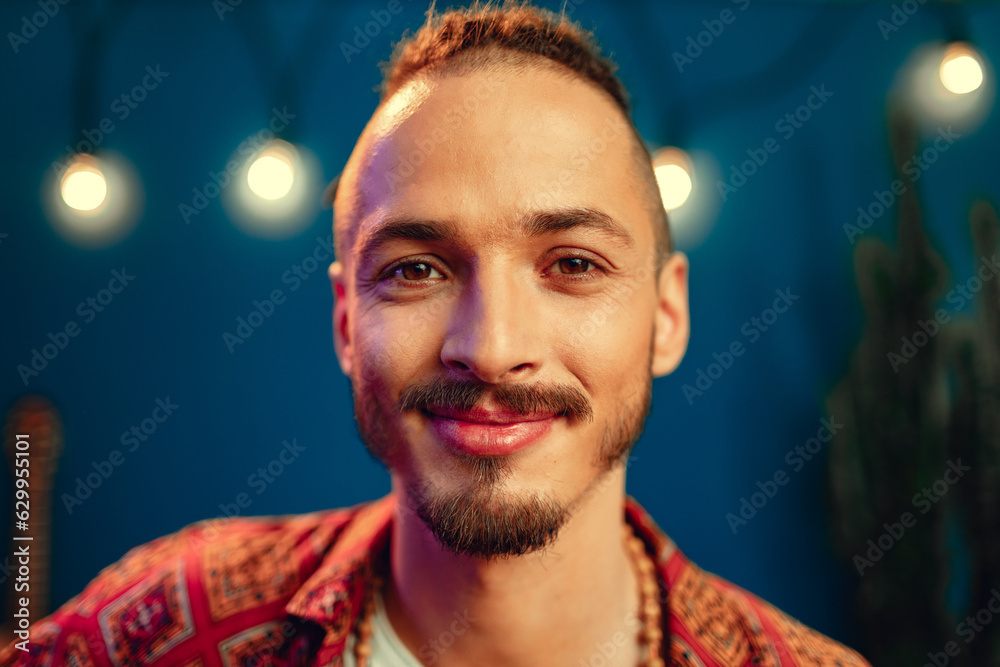 Portrait of a positive handsome caucasian guy with dreadlocks against blue background Portrait of a positive handsome caucasian guy with dreadlocks against blue background